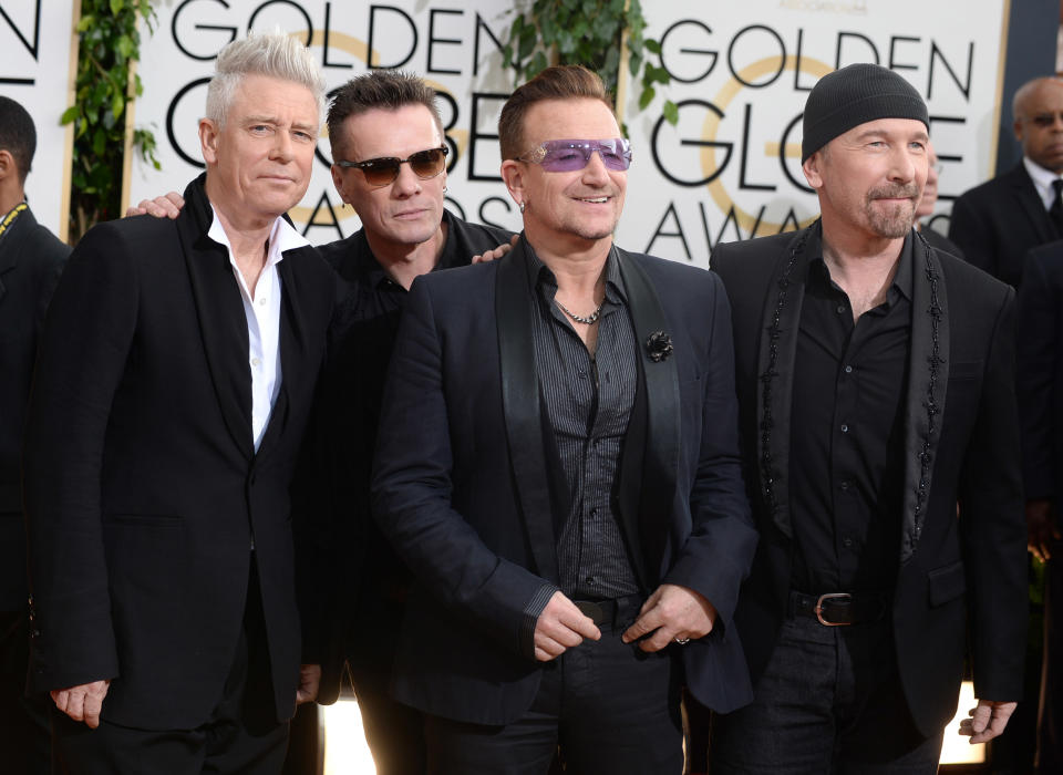 Members of the Irish rock band U2, from left, Adam Clayton, Larry Mullen, Jr., Bono, and The Edge arrive at the 71st annual Golden Globe Awards at the Beverly Hilton Hotel on Sunday, Jan. 12, 2014, in Beverly Hills, Calif. (Photo by Jordan Strauss/Invision/AP)