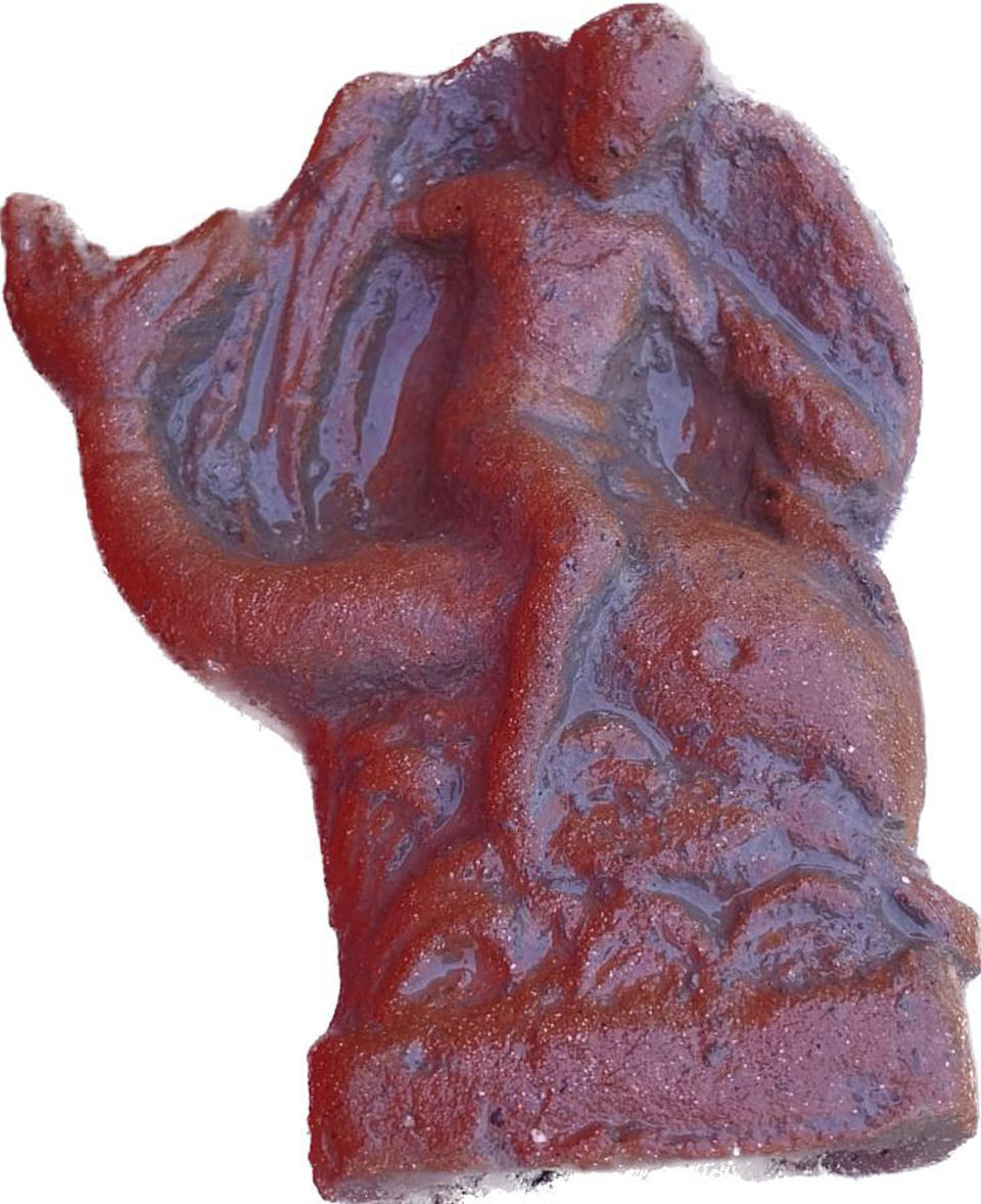 This undated photo shows a terracotta figurine of Eros riding a dolphin found in a newly discovered sanctuary, which dates from the 5th century B.C., that was first identified in 2019 along the ancient city walls of Paestum, Southern Italy. The excavations of the sanctuary in the ancient city of Paestum have unearthed seven terracotta bull heads and a figurine of Eros riding a dolphin that shines new light on the religious life and rituals of the ancient Greek city, culture ministry officials said Saturday, April 15, 2023. (Paestum Velia Archeological Park via AP)