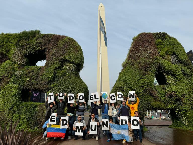 Un grupo de venezolanos sostienen carteles que dicen 