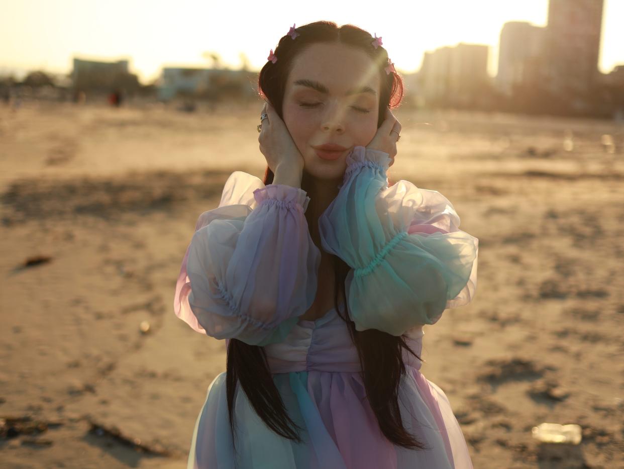 Autistic woman in a dress posing for the camera at the beach in California