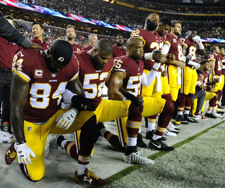 Washington Redskins tight end Niles Paul (84), linebacker Ryan Anderson (52) and linebacker Chris Carter (55) kneel with teammates during the national anthem before the game between the Redskins and the Oakland Raiders in Maryland on Sunday. (Photo: Brad Mills/USA Today Sports via Reuters)