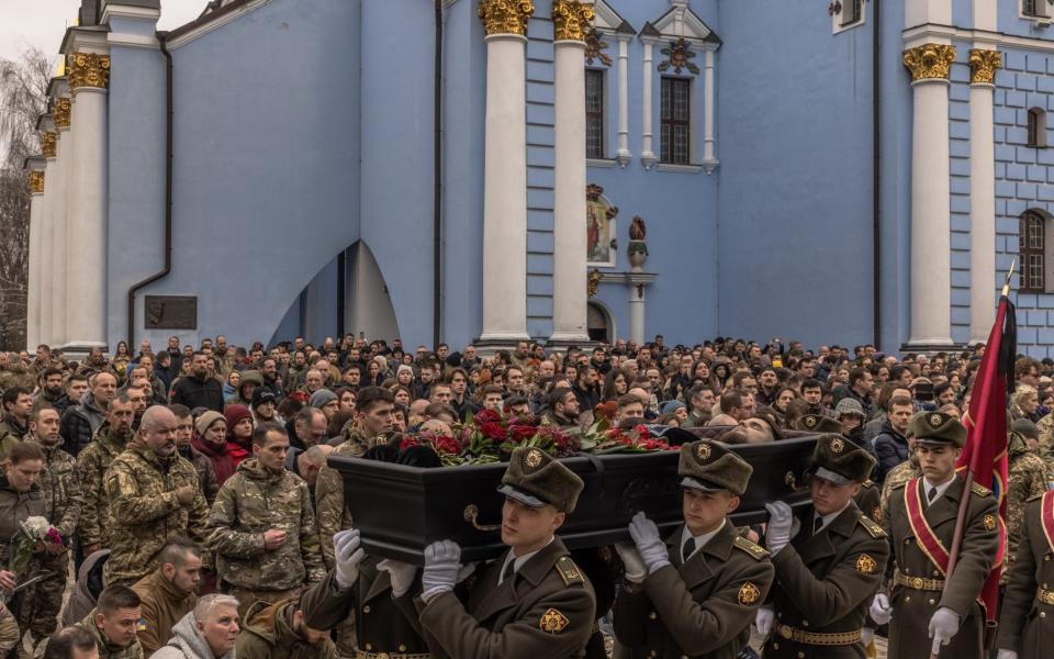 A military guard of honour carries the coffin across Independence Square as mourners gather - Roman Pilipey/Getty Images Europe