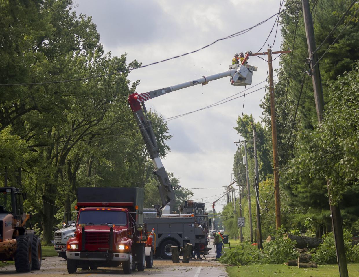 Workers repair power lines downed by yesterday's storm in Springfield Township, Ohio, on Tuesday, Aug. 30, 2022.