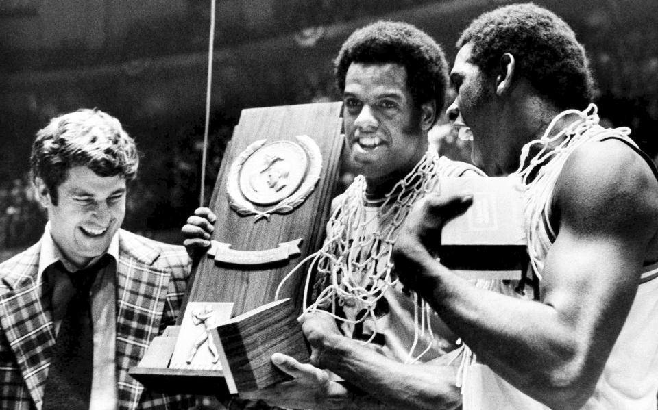 FILE - Indiana coach Bobby Knight, left, and team members Scott May, center, and Quinn Buckner, right, celebrate with the trophy after winning the NCAA college basketball championship, beating Michigan 86-68 in Philadelphia, March 30, 1976. (AP Photo/File)