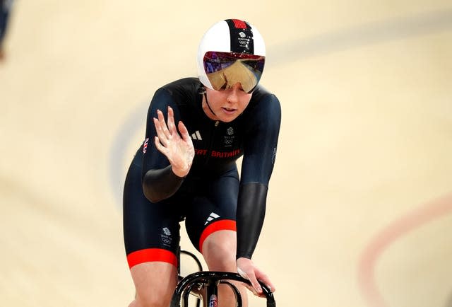 Emma Finucane waves on the track. 