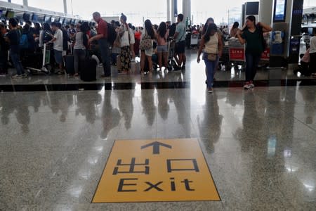 Passengers queue as the airport reopened a day after flights were halted due to a protest, at Hong Kong International Airport, China