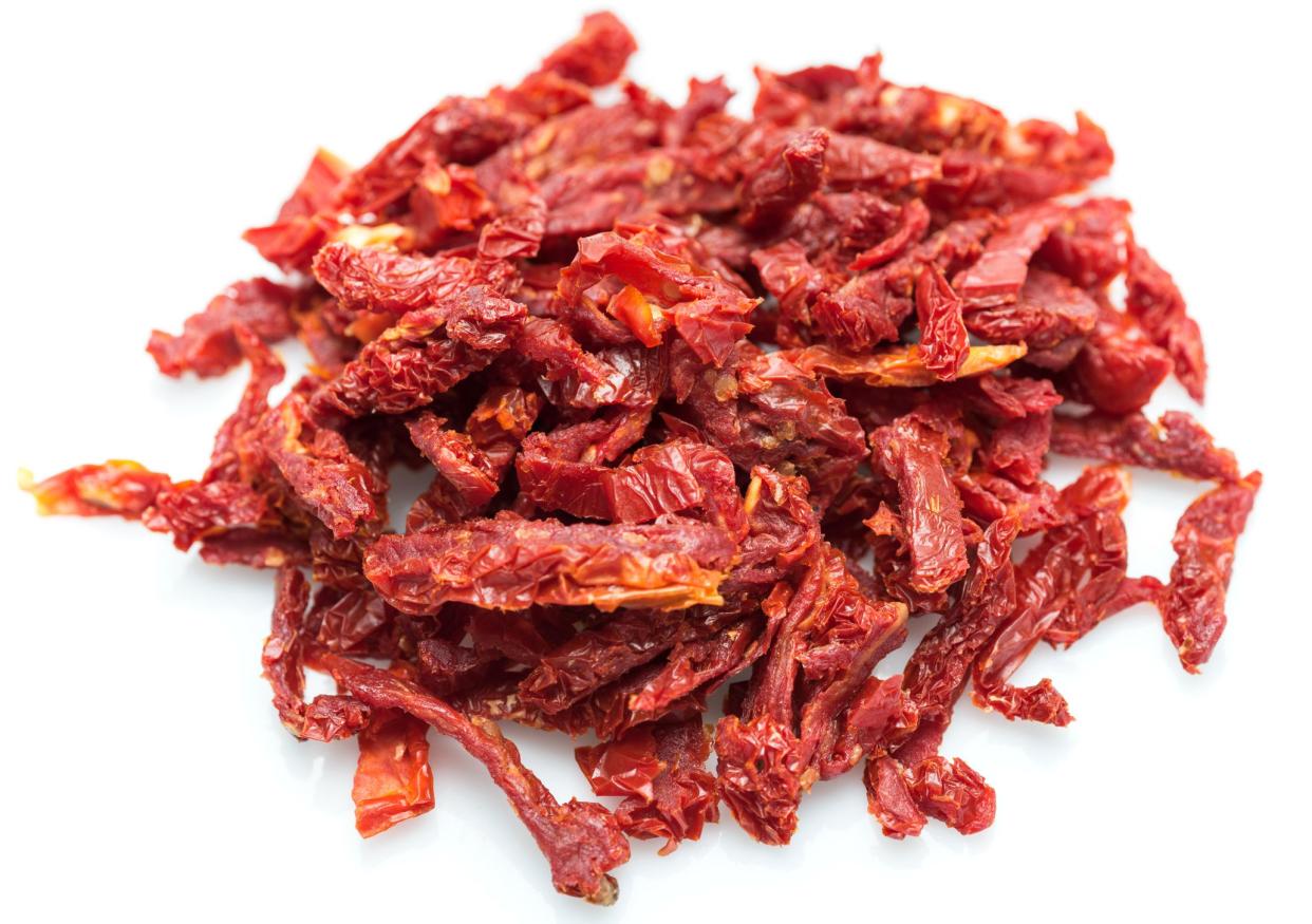 Heap of sliced sun dried tomatoes on white background