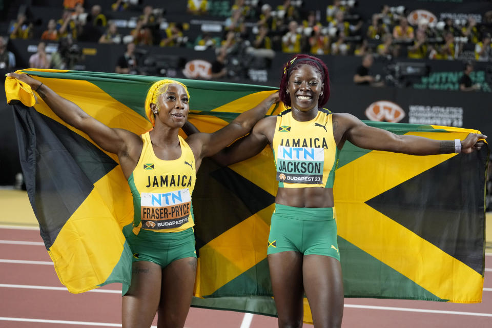 Bronze medalist Shelly-Ann Fraser-Pryce and silver medalist Shericka Jackson, both of Jamaica, from left, pose after the Women's 100-meter final during the World Athletics Championships in Budapest, Hungary, Monday, Aug. 21, 2023. (AP Photo/Matthias Schrader)