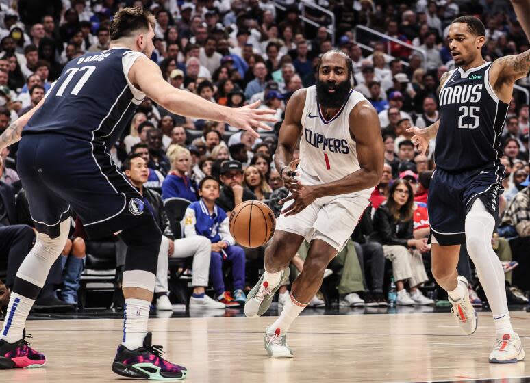 Clippers guard James Harden loses control of the ball as he drives past Mavericks guard Luka Doncic