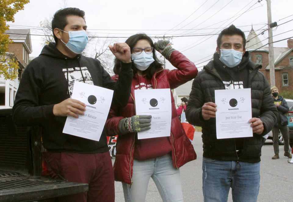 Enrique Balcazar, left, Zully Palacios Rodriguez, center, and Victor Diaz, right, of the group Migrant Justice, poses outside the federal courthouse on Wednesday, Oct. 28, 2020, in Burlington, Vt. U.S. Immigration and Customs Enforcement has agreed not to deport them in a settlement of their lawsuit alleging that they were targeted because of their activism. (AP Photo/Lisa Rathke)