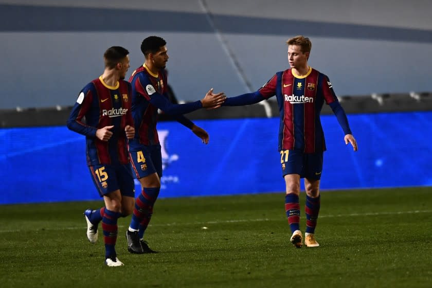 Barcelona's Frenkie de Jong, right, celebrates with teammate Ronald Araujo after scoring the opening goal during Spanish Super Cup semi final soccer match between Barcelona and Real Sociedad at Nuevo Arcangel stadium in Cordoba, Spain, Wednesday, Jan. 13, 2021. (AP Photo/Jose Breton)