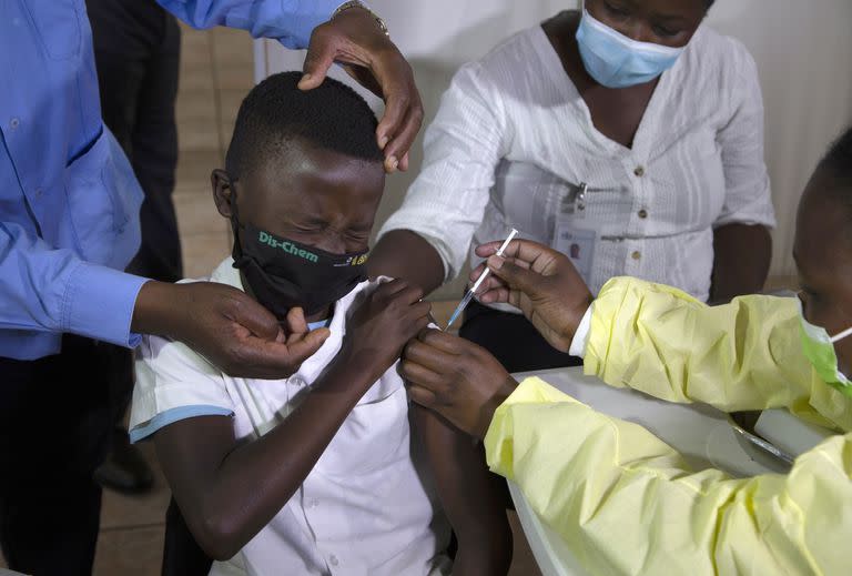 Archivo - Un niño gesticula mientras recibe una inyección de la vacuna de Pfizer contra el COVID-19 en Diepsloot Township cerca de Johannesburgo, el jueves 21 de octubre de 2021 (AP Foto/Denis Farrell, Archivo)