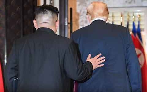 North Korea's leader Kim Jong Un (L) and US President Donald Trump leave following a signing ceremony - Credit: SAUL LOEB /AFP
