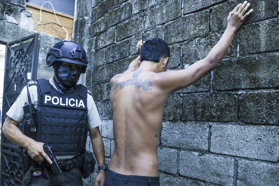 Un residente, apoyado en una pared con los brazos separados, durante un registro policial en busca de armas o drogas dentro de un operativo para combatir a las bandas delictivas, en Guayaquil, Ecuador, el 4 de abril de 2024. (AP Foto/César Muñoz)