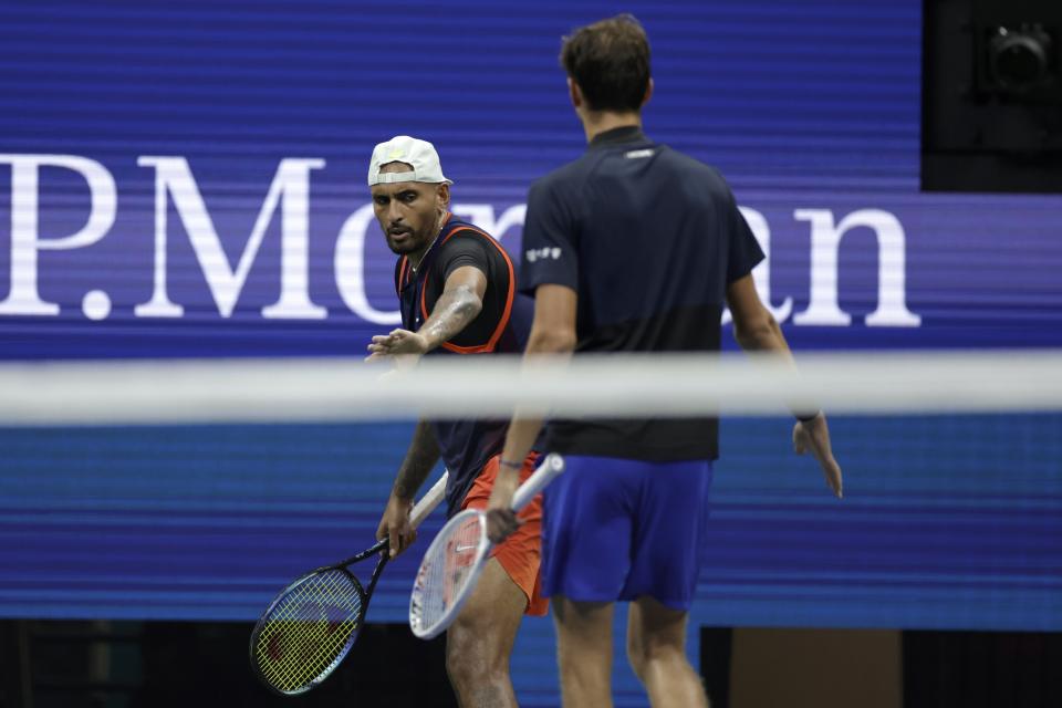 Daniil Medvedev, front, of Russia, walks over to check on Nick Kyrgios, of Australia, who took a hard spill after returning a shot during the fourth round of the U.S. Open tennis championships, Sunday, Sept. 4, 2022, in New York. (AP Photo/Adam Hunger)