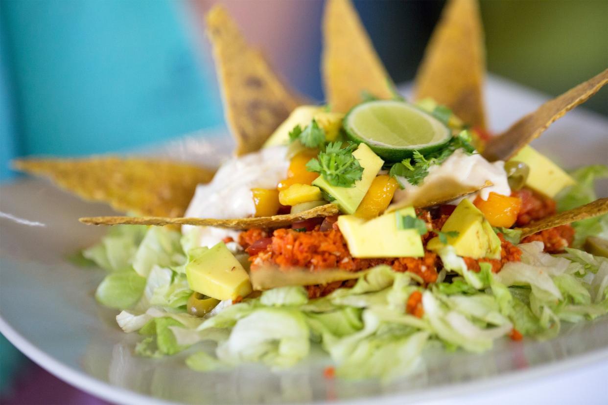 Taco salad decorated with tortilla chips on a white plate