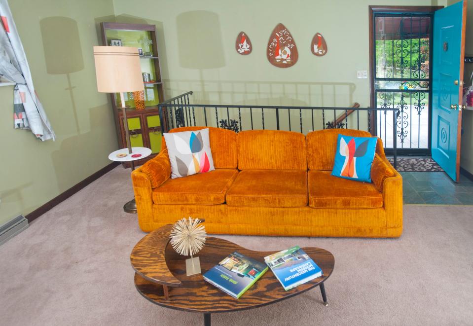 This orange sofa helps decorate the mid-century styled Clarksville living room of John and Jennifer Martin.15 July 2019