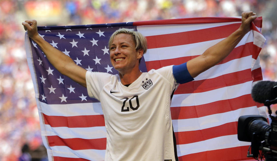 FILE - In this July 5, 2015, file photo, United States' Abby Wambach holds an American flag after the U.S. beat Japan 5-2 in the FIFA Women's World Cup soccer championship in Vancouver, British Columbia, Canada. Wambach has reached out to an 8-year-old Nebraska girl who says her team was disqualified from a tournament because she "looks like a boy." The Springfield Soccer Association tells WOWT-TV that a misprint in the team’s roster identified Hernandez as a boy in “violation of state and tournament rules" and her appearance wasn’t an issue. (AP Photo/Elaine Thompson, File)