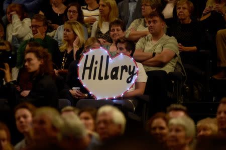 Members of the audience hold a sign as former U.S. Secretary of State, Hillary Clinton is interviewed by Mariella Frostrup at the Cheltenham Literature Festival in Cheltenham, Britain October 15, 2017. REUTERS/Rebecca Naden