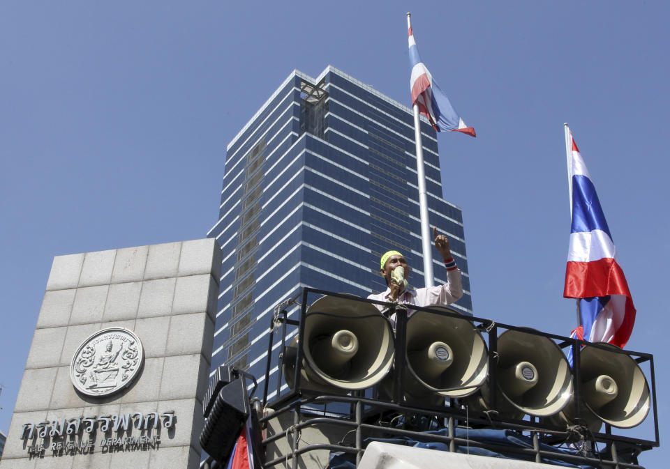 An anti-government protester speaks to protestors from a truck while blocking the Revenue Department in Bangkok, Thailand Monday, Jan. 13, 2014. Anti-government protesters aiming to shut down central Bangkok took over key intersections Monday, halting much of the traffic into the Thai capital's main business district as part of a months-long campaign to overthrow the democratically elected prime minister. (AP Photo/Apichart Weerawong)