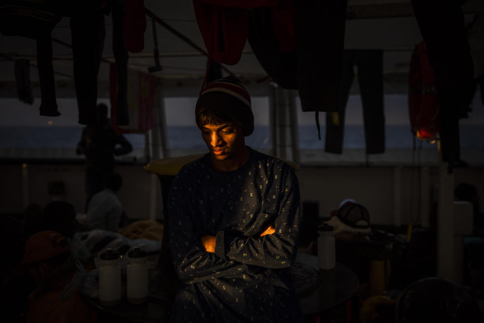 In this Sunday Jan. 12, 2020 photo, Emon, 18, from Bangladesh rests aboard the Open Arms rescue vessel as the ship sails north with 118 people from different nationalities who were rescued on Friday off the Libyan coast. (AP Photo/Santi Palacios)