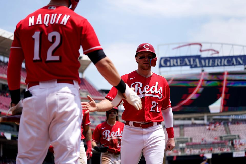 Cincinnati Reds third baseman Brandon Drury (22) is congratulated by Cincinnati Reds right fielder Tyler Naquin (12) after scoring in the second inning of a baseball game, Wednesday, May 11, 2022, at Great American Ball Park in Cincinnati.