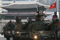 South Korean soldiers travelling in their self-propelled artillery vehicles, wave to the crowd during a parade marking 65th anniversary of Korea Armed Forces Day in front of Sungnyemun Gate in central Seoul October 1, 2013. (REUTERS/Kim Hong-Ji)