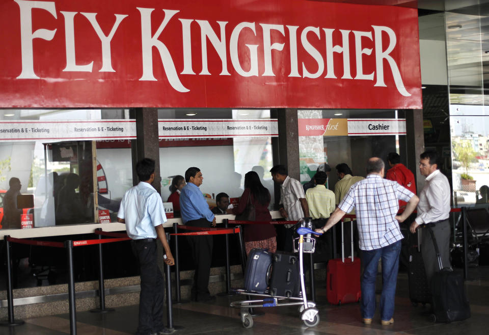 Passengers wait outside Kingfisher ticket counter at the domestic airport in Mumbai, India, Tuesday, March 20, 2012. The severely cash-strapped airlines may now face the risk of cancellation of its flying permit after the Directorate General of Civil Aviation (DGCA) expressed doubts on its ability to maintain a steady schedule with a declining number of operable aircrafts and ongoing problems with pilots leaving the company.(AP Photo/Rafiq Maqbool)