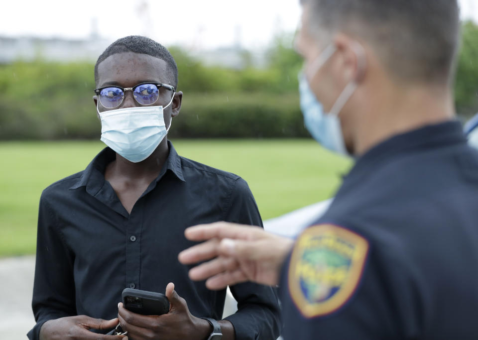 In this, June 18, 2020 photo, demonstration organizer Weidmayer Pierre, left, talks with Palm Beach Police Capt. Joe Guelli as Guelli gives him a tour of sites that could accommodate the protesters in West Palm Beach, Fla. Before the death of George Floyd, business-management student Pierre had planned to spend his Florida summer break working at Wal-Mart. Instead, the 19-year-old has been organizing a protest every few days in Palm Beach County, determined to channel the groundswell of energy around the world into meaningful, peaceful reform in his hometown. (AP Photo/Wilfredo Lee)