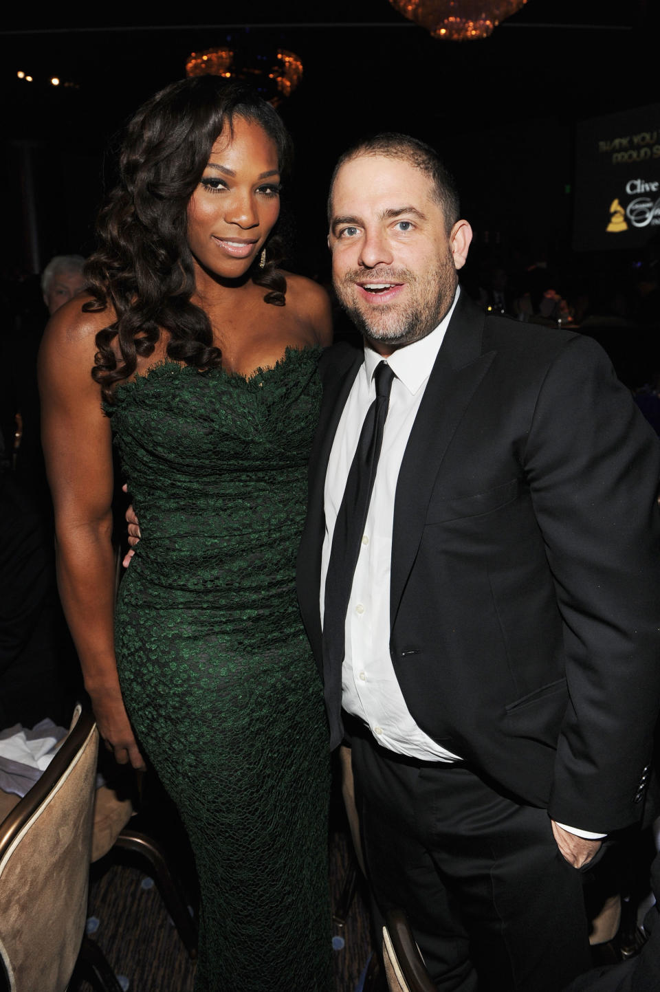 Serena in a green dress with Brett in a black suit at an event