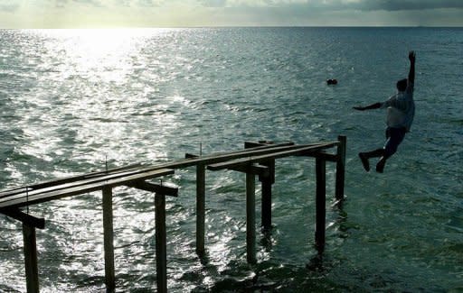 A school boy escapes the heat by leaping into the lagoon on Funafuti Atoll, Tuvalu, in 2004. Tiny Pacific nations which are most at threat from rising seas - such as Tuvalu - have vowed to dump diesel and other dirty expensive fuels blamed for causing global warming and replace them with clean sources