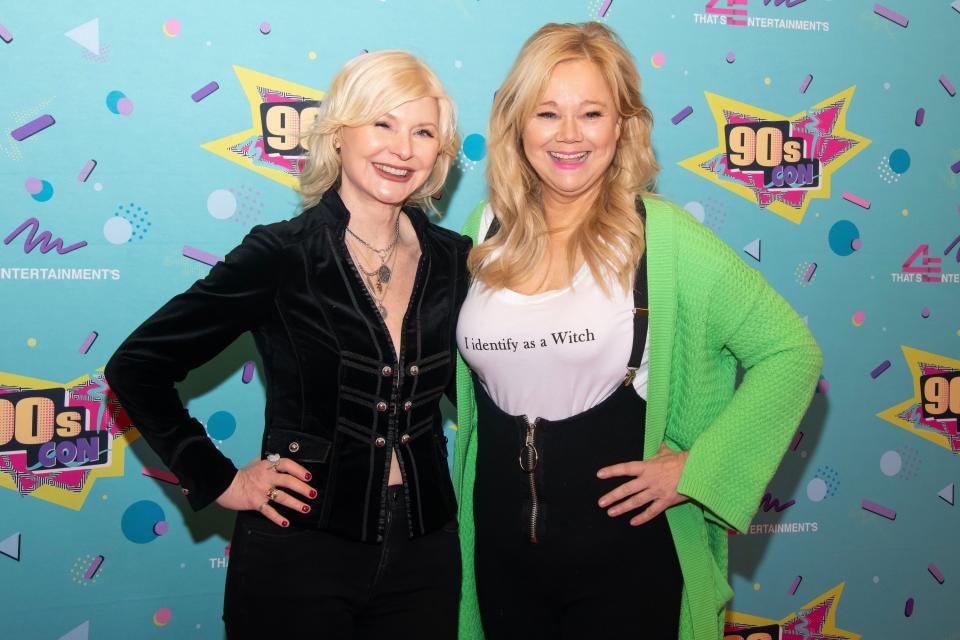 Beth Broderick on the left and Caroline Rhea on the right as the pose on the red carpet. Caroline is wearing a t-shirt that says, "I identify as a Witch"