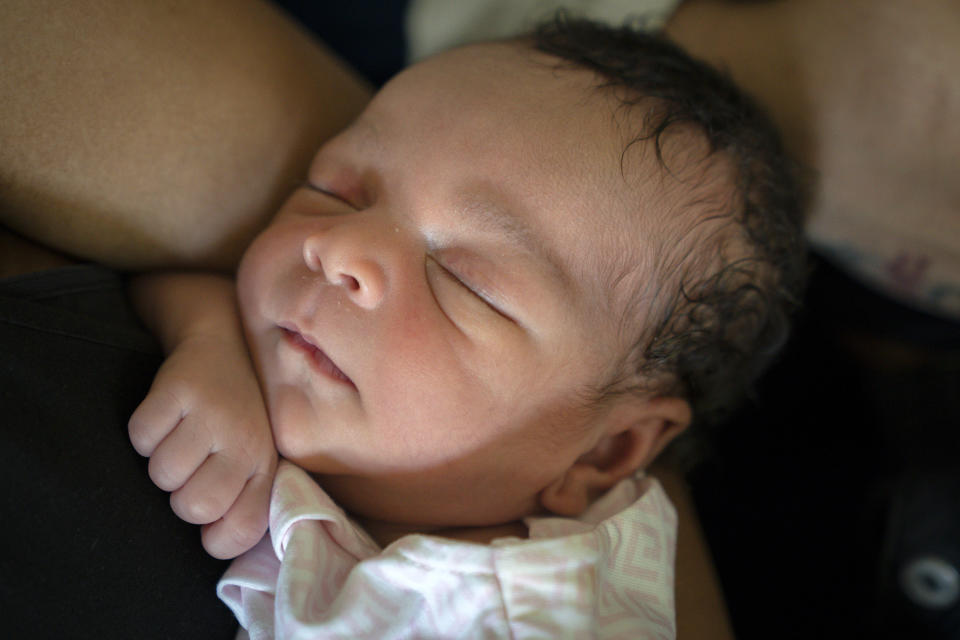 Kali Wrights sleeps while being held by her mother, Aaliyah Wright, 25, of Washington, during a visit to her grandmother's home in Accokeek, Md., Tuesday, Aug. 9, 2022. A landmark social program is being pioneered in the nation’s capital. Coined “Baby Bonds,” the program is designed to narrow the wealth gap. The program would provide children of the city’s poorest families up to $25,000 when they reach adulthood. (AP Photo/Jacquelyn Martin)