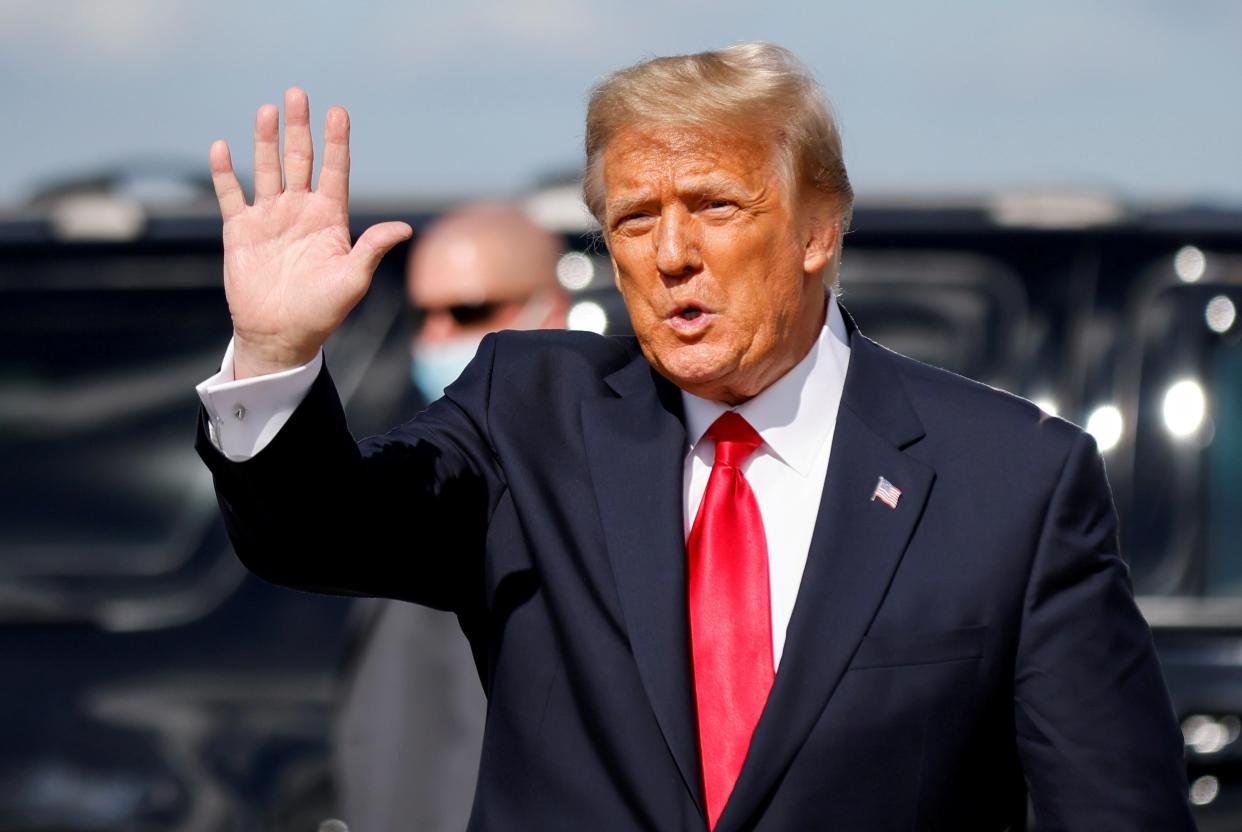Donald Trump waves as he arrives at Palm Beach International Airport in West Palm Beach, Florida, on 20 January 2021 ((Reuters))