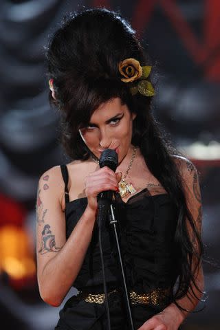 <p>Peter Macdiarmid/Getty</p> Amy Winehouse performing on the 2008 Grammys from London