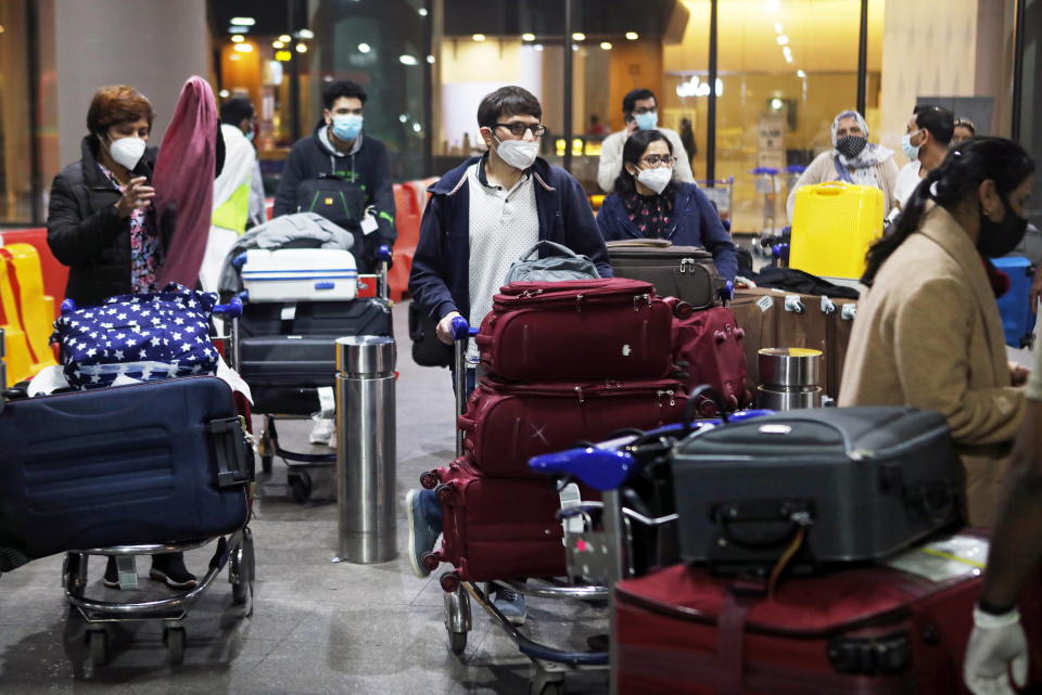 Passengers wearing protective face masks wait to exit upon arrival at Chhatrapati Shivaji Maharaj International Airport after India cancelled all flights from the UK over fears of a new strain of the coronavirus disease (COVID-19), in Mumbai, India, December 22, 2020. REUTERS/Francis Mascarenhas