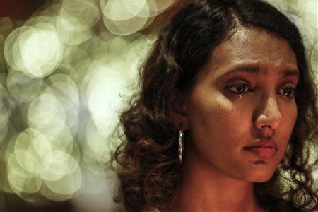 A woman weeps during a candlelight vigil for the passengers of the missing Malaysia Airlines MH370 in central Kuala Lumpur March 27, 2014. REUTERS/Athit Perawongmetha