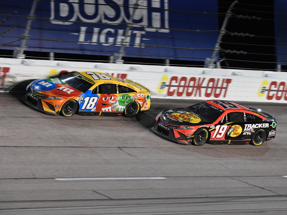 DARLINGTON, SC - SEPTEMBER 04: Kyle Busch (#18 Joe Gibbs Racing M&M's Toyota) and Martin Truex Jr (#19 Joe Gibbs Racing Bass Pro Shops Toyota) through Turn 1 during the running of NASCAR Cup Series Cook Out Southern 500 on September 04, 2022, at Darlington Raceway in Darlington, SC.(Photo by Jeffrey Vest/Icon Sportswire via Getty Images)