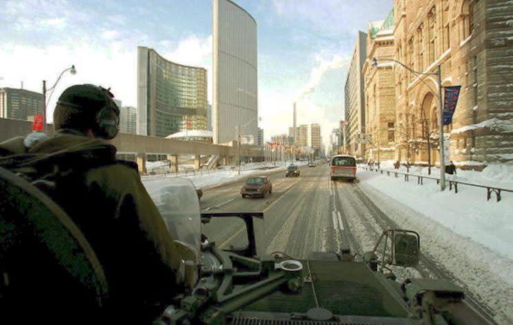 TORONTO, CANADA: Canadian Army officer John Dunn patrols downtown Toronto 15 January in an armored personnel carrier following heavy snow and frigid temperatures in eastern and central Canada. For the third day in a row Toronto -- Canada's largest city and financial capital -- was working at half speed with businesses, schools and government offices shut down. Thomas CHENG/AFP PHOTO (Photo credit should read THOMAS CHENG/AFP/Getty Images)