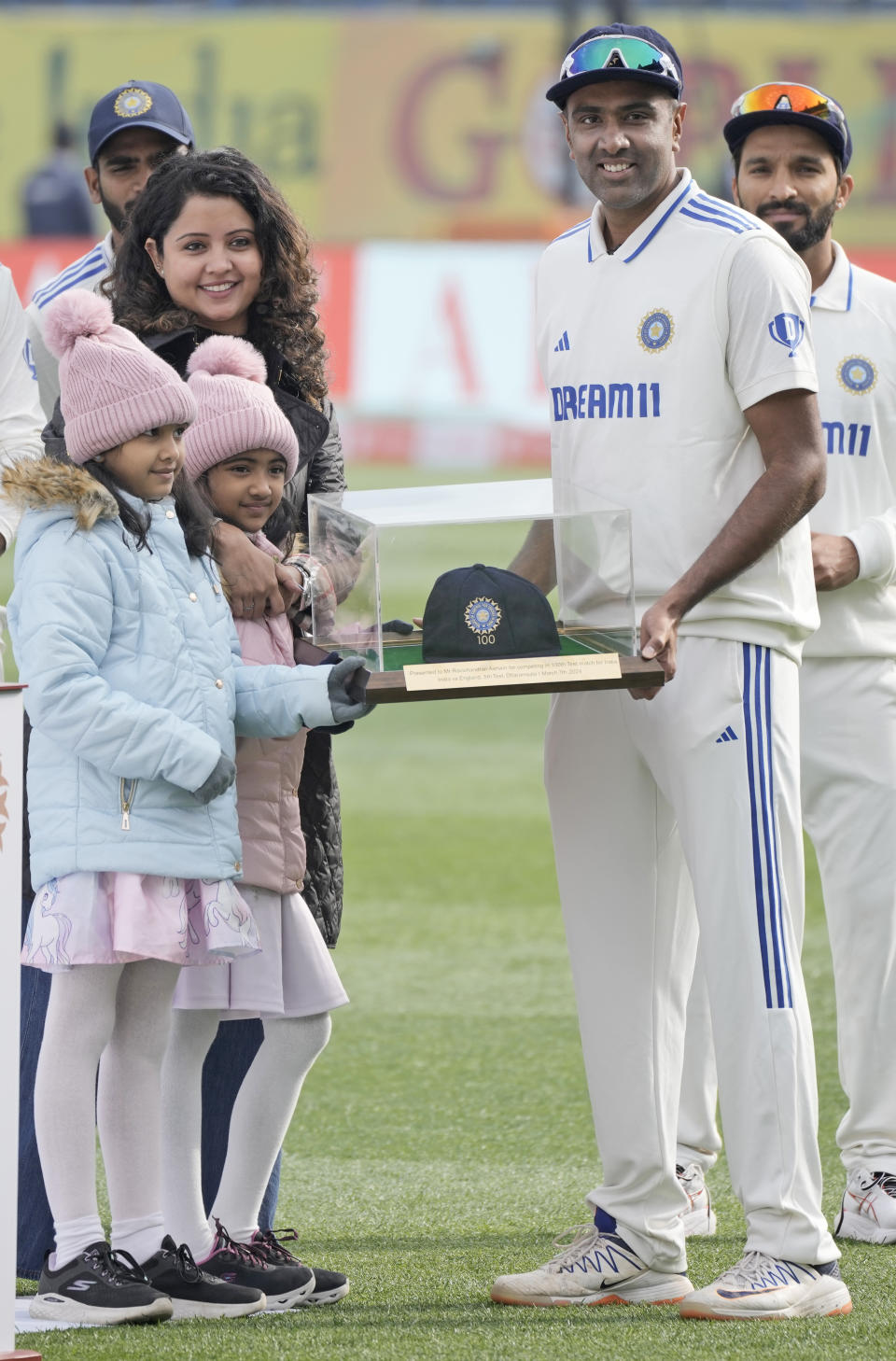 India's Ravichandran Ashwin holds a commemorative cap with his family on his 100th test match appearance on the first day of the fifth and final test match between England and India in Dharamshala, India, Thursday, March 7, 2024. (AP Photo/Ashwini Bhatia)