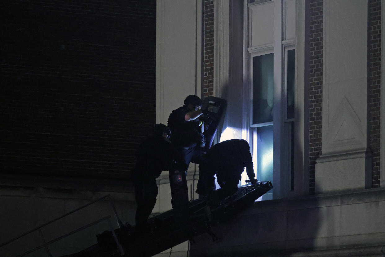 NYPD officers enter Hamilton Hall through a window.