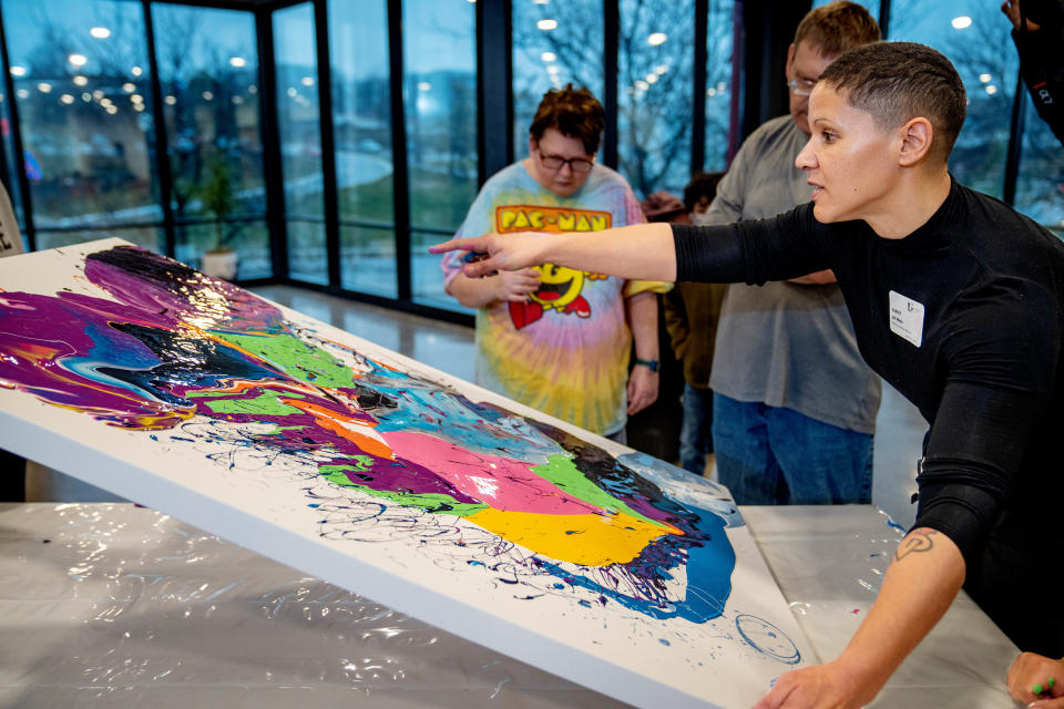 Jill Wells works on a paint pour painting with a group of emerging Iowa based-artists at Mainframe Studios in Des Moines.