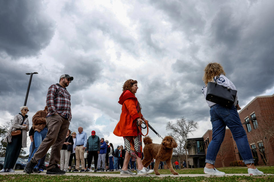 A woman with a dog stands in line to cast her vote in the South Carolina Republican presidential primary election, at the Jennie Moore Elementary School, in Mount Pleasant, South Carolina, U.S., February 24, 2024. REUTERS/Evelyn Hockstein     TPX IMAGES OF THE DAY