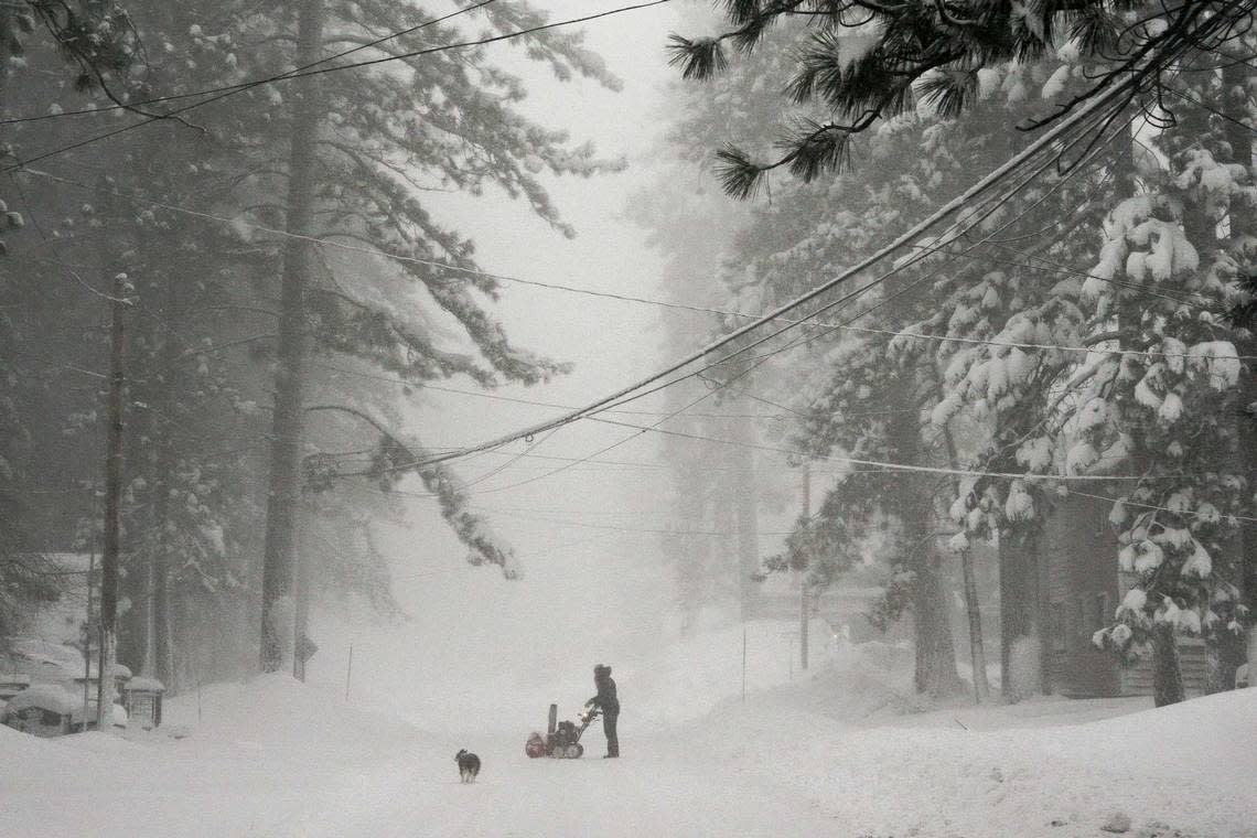 A person tries to clear snow from a road during a storm, Saturday, March 2, 2024, in Truckee, Calif. A powerful blizzard howled Saturday in the Sierra Nevada as the biggest storm of the season shut down a long stretch of Interstate 80 in California and gusty winds and heavy rain hit lower elevations, leaving tens of thousands of homes without power. Brooke Hess-Homeier/AP