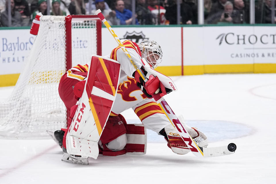 Calgary Flames goaltender Jacob Markstrom deflects a shot by the Dallas Stars in the first period of an NHL hockey game, Monday, March 6, 2023, in Dallas. (AP Photo/Tony Gutierrez)