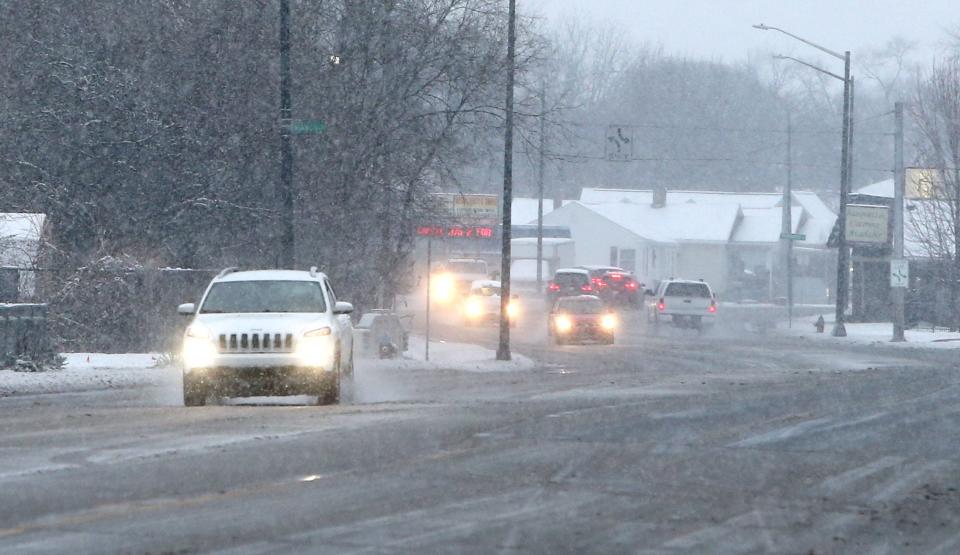 Motorists drive along streets that were plowed to remove the slushy snow Tuesday, Jan. 9, 2024, along Lincoln Way East in Mishawaka.