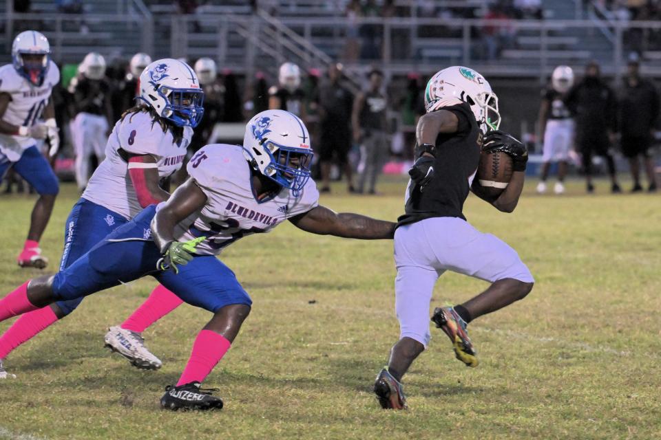 Pahokee’s Jermaine Graddick reaches an arm out, trying to bring down the Atlantic bal-carrier during a regular season game on Oct. 6, 2023.