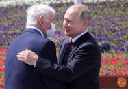 Russian President Vladimir Putin, right, congratulates the president of the Scientific Research Institute for Emergency Children's Surgery and Traumatology Leonid Roshal during a ceremony of handing Gold Stars medals to heroes of labor marking the Day of Russia holiday in Moscow, Russia, on Friday, June 12, 2020. The ceremony marked the first big public event Putin attended since announcing a nationwide lockdown more than two months ago. (Mikhail Klimentyev, Sputnik, Kremlin Pool Photo via AP)