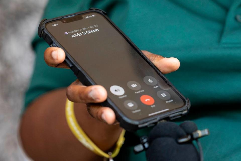 Tamara McGraw holds the phone while her husband, Joshua Steven McGraw, speaks during a press conference. The McGraws joined others who spoke about the conditions at Alvin S. Glenn Detention Center.