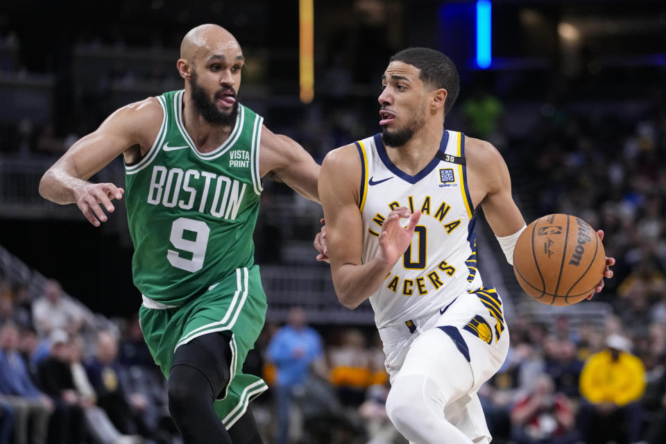 Indiana Pacers guard Tyrese Haliburton (0) drives on Boston Celtics guard Derrick White (9) during the first half of an NBA basketball game in Indianapolis, Monday, Jan. 8, 2024. Haliburton was injured on the play. (AP Photo/Michael Conroy)